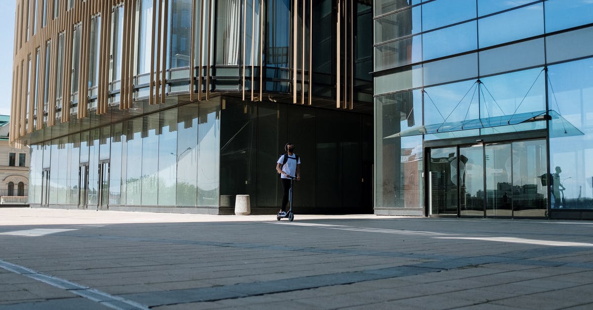 Can you bring an electric scooter on Flixbus? - Man in Black Jacket and Black Pants Standing in Front of Building