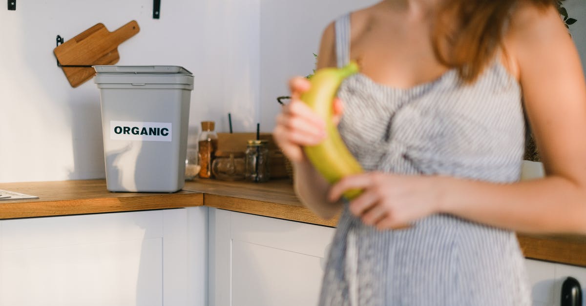 Can you bring vitamins into China? - Crop woman with organic banana in hands standing in kitchen