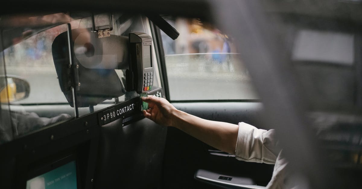 Can you buy a plane ticket from a Swedish online travel agency with a US credit card? - Side view of crop faceless male passenger sitting on backseat and using credit card reader to pay for trip in taxi