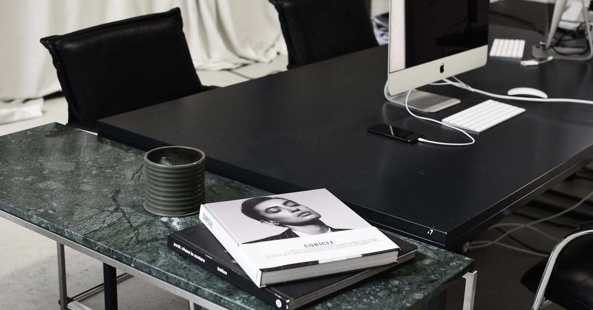 Can you charge your phone "airside" at Malaga Airport (AGP) - Modern computers and smartphone placed on black table near marble table with books in contemporary workspace