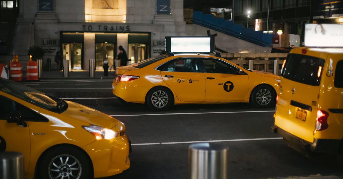 Can you drive to the US on temporary Canadian plates? - From above of contemporary shiny yellow cabs riding on asphalt roadway in New York at night