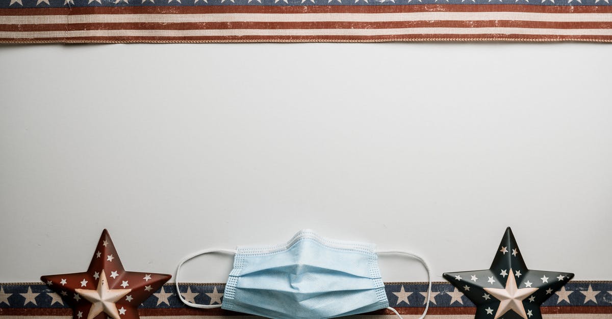 Can you fly from Zagreb to the US without quarantining? - Top view of American ribbons with stars and stripes near sterile mask during coronavirus pandemic