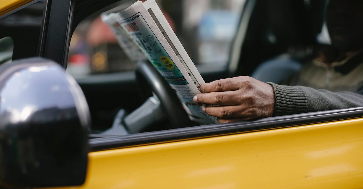 Can you rent / drive a car in the USA with just the paper counterpart of the UK driver's license? - Side view of crop anonymous ethnc male driver reading information in newspaper article while waiting for client Can you rent / drive a car in the USA with just the paper counterpart of the UK driver's license? - Side view of crop anonymous ethnc male driver reading information in newspaper article while waiting for client