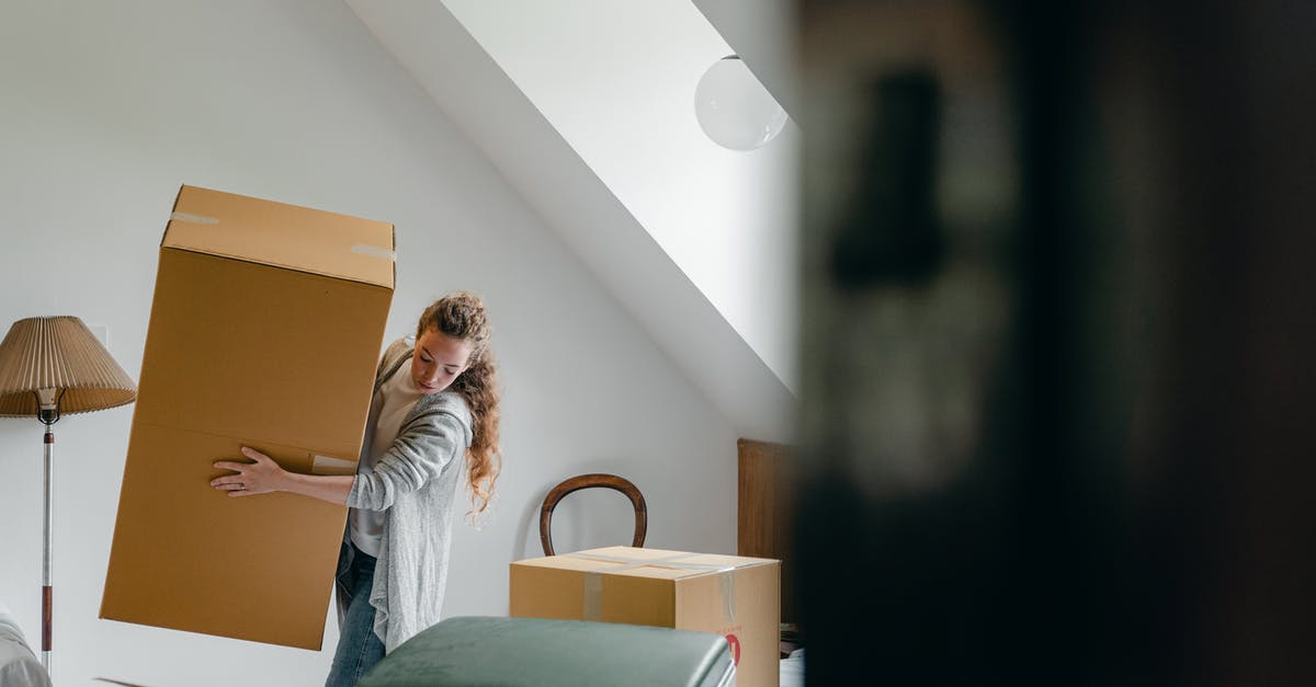 Can you take large umbrellas on a plane? - Woman carrying boxes in new apartment