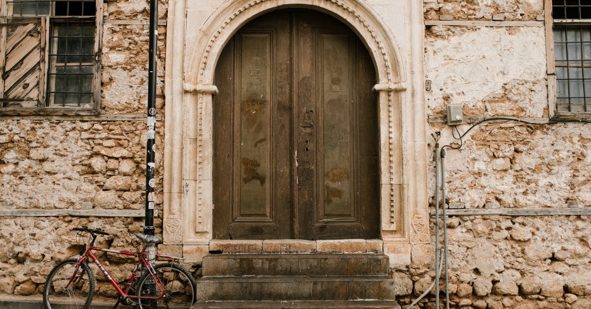 Canada: Entry by vehicle - Old stone building with arched wooden door