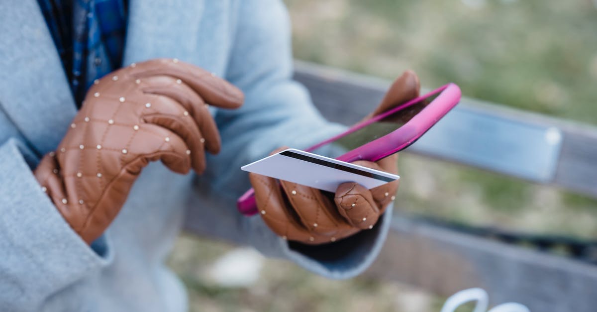 Canadian visitor visa online application fee payment - Crop anonymous female in blue coat and leather gloves with credit card making online purchase via smartphone while sitting on bench in city park