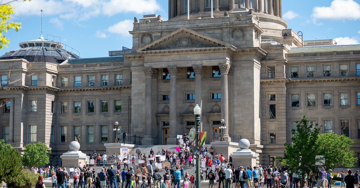 Canadian wants to go to US for meetings - People gathering outside majestic Idaho State Capitol building for meeting on sunny day in Boise City