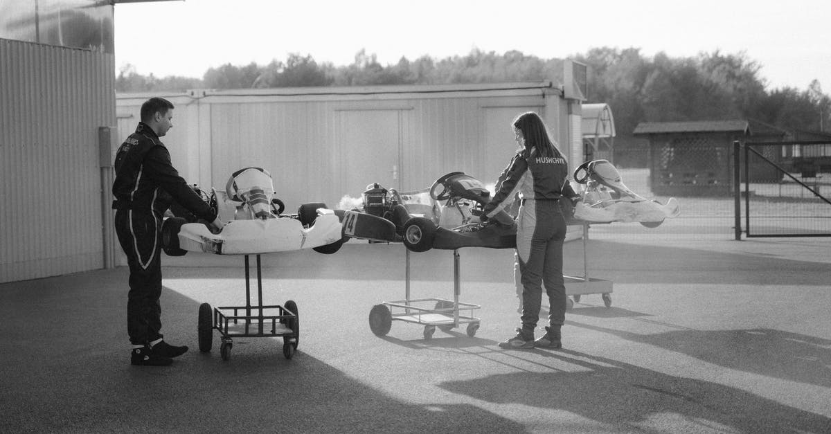 Cancelled Enhanced Drivers License - Man in Black Jacket and Pants Sitting on Black Chair Near White Airplane in Grayscale Photography