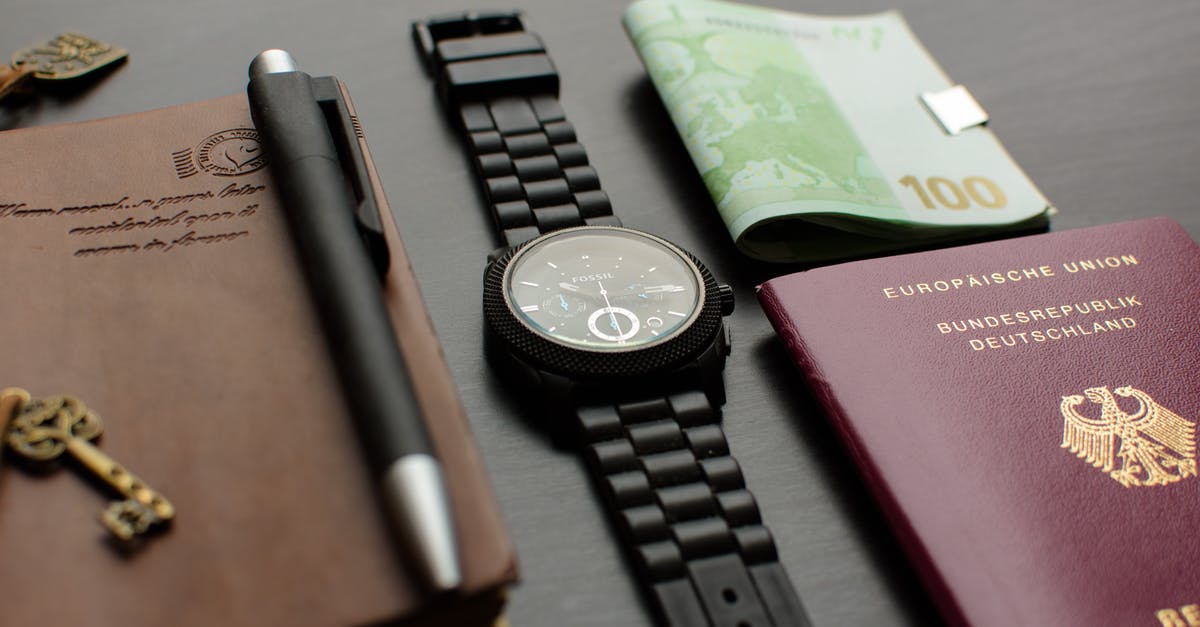 Cancelled stamp on passport [closed] - Round Black Chronograph Watch on Table Near Germany Passport an Banknote on Table