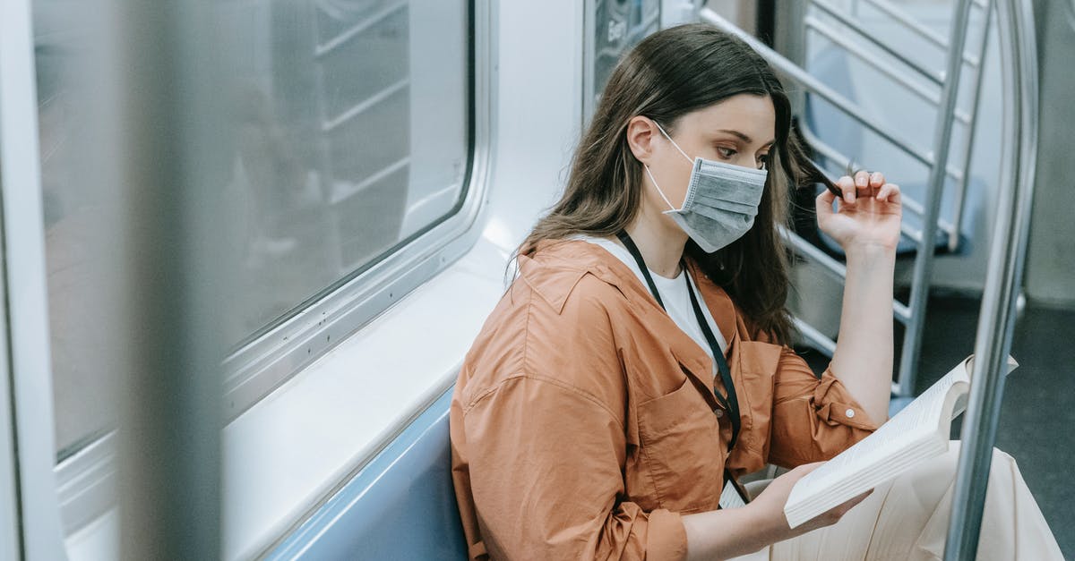 Cancelling booking on Booking.com due to COVID-19 - Photo of a Woman Reading Book Inside the Train