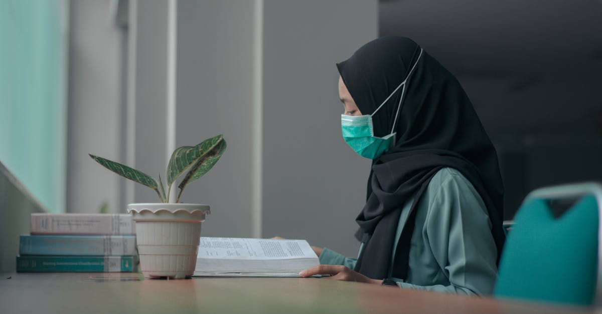 Cancelling booking on Booking.com due to COVID-19 - Woman in Black Hijab Reading a Book