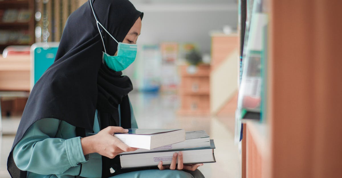 Cancelling booking on Booking.com due to COVID-19 - Woman Wearing Face Mask Holding a Book