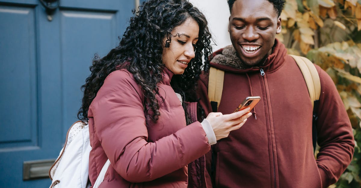 Cannot enter check out date in China Visa itinerary Section 2.6 - Multiethnic happy couple smiling and checking smartphone on street