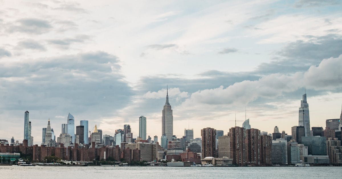 Capital with fewest resident embassies [closed] - Cityscape of contemporary metropolis with high rise towers located on river shore under cloudy sky