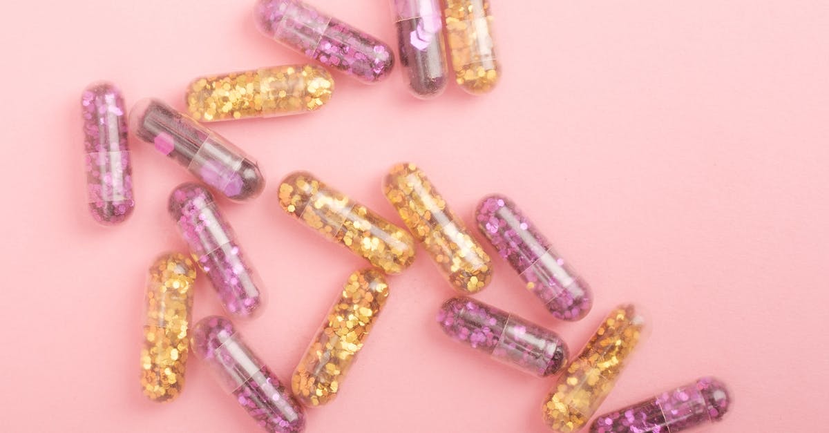 Capsule hotels in New-York JFK - Pile of sparkling drug capsules scattered on pink surface