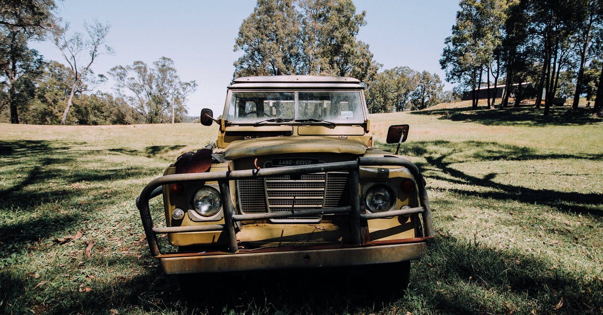 Car damage caused by potholes in the EU, what to do? - Grunge abandoned car left on grassy meadow