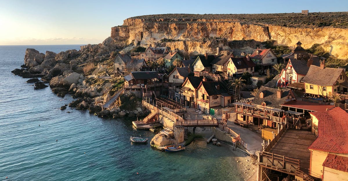 Car on ferry between Gozo and Malta during the Christmas period - Wide-angle Photography of Buildings Beside Seashore