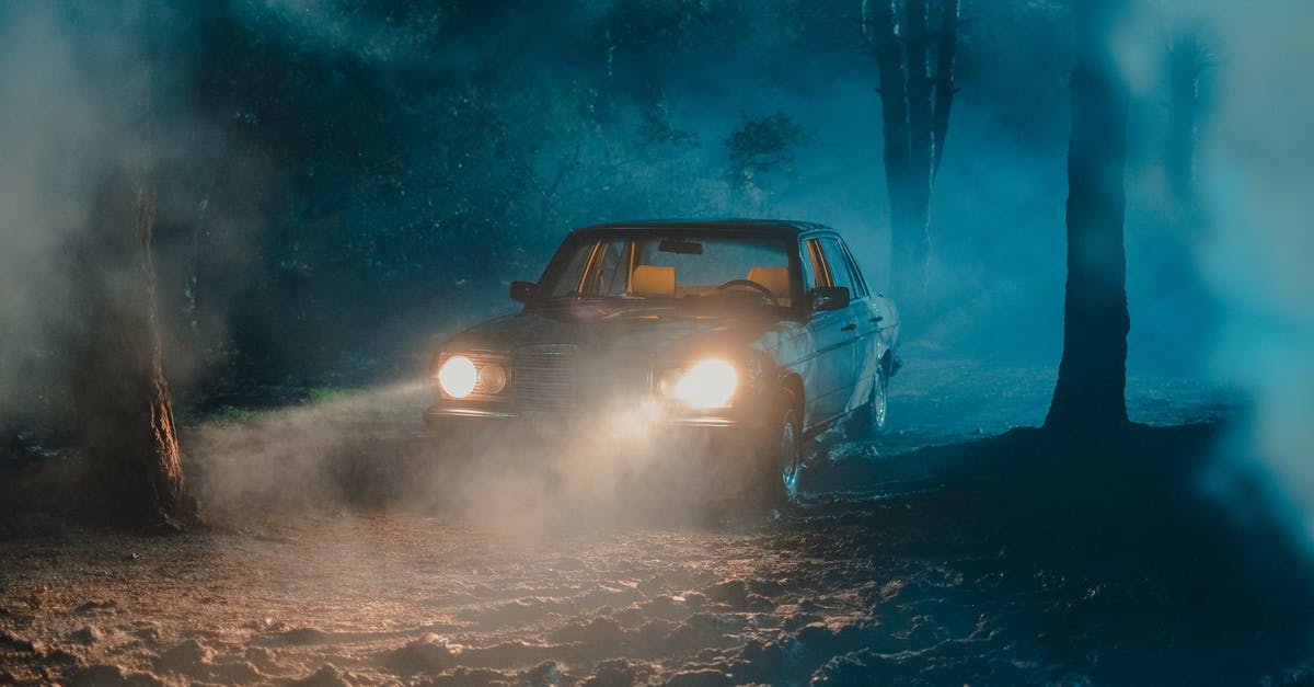 Car rental in California with no credit history - Old fashioned car with luminous headlights in dark forest