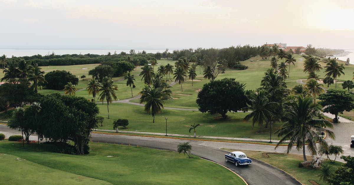 Car rental in Cuba - Vintage Car Passing Golf Course