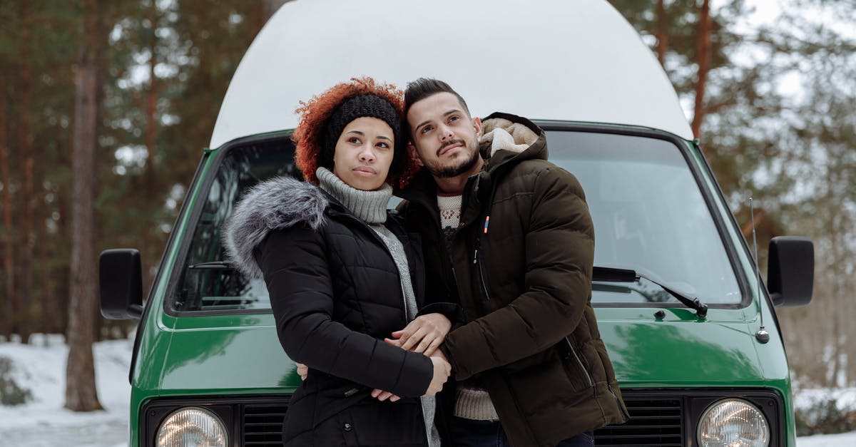 Car rental in Germany - are winter tyres included? - Man and Woman Being Affectionate While In Front of a Green Van