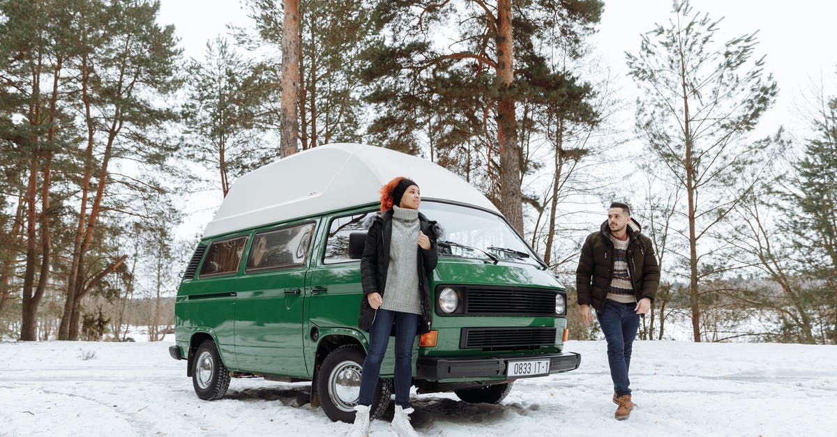 Car rental in Germany - are winter tyres included? - Couple In Front of a Green Van While in the Forest