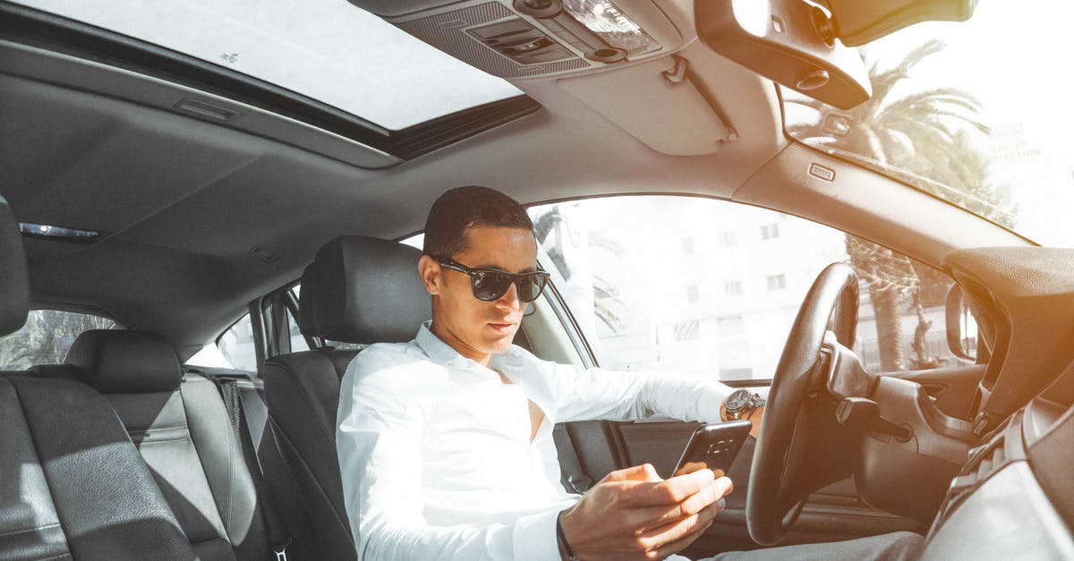 Car rental with baby seats: is it better to carry seats or rent seats? - Man in White Dress Shirt Holding Smartphone