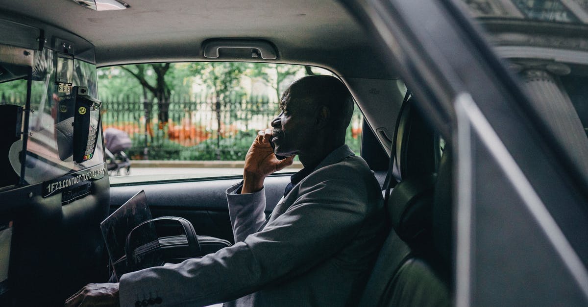 Car share in Las Vegas? - Side view of African American male discussing strategy on mobile phone in automobile