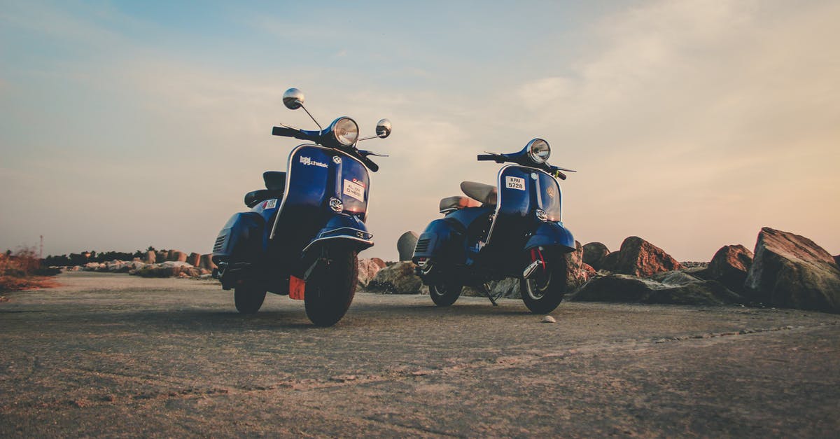 Caravan travels, the rough way - Blue mopeds parked on empty road in countryside