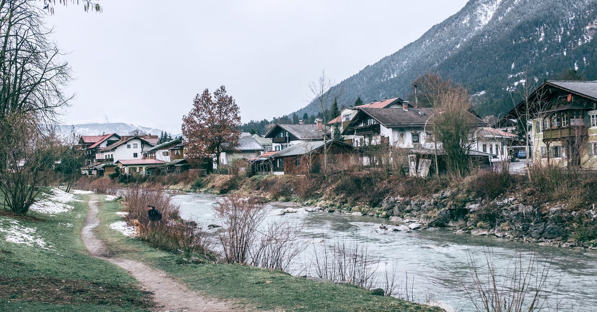 Caravan travels, the rough way - Old houses near river and big mountain in winter