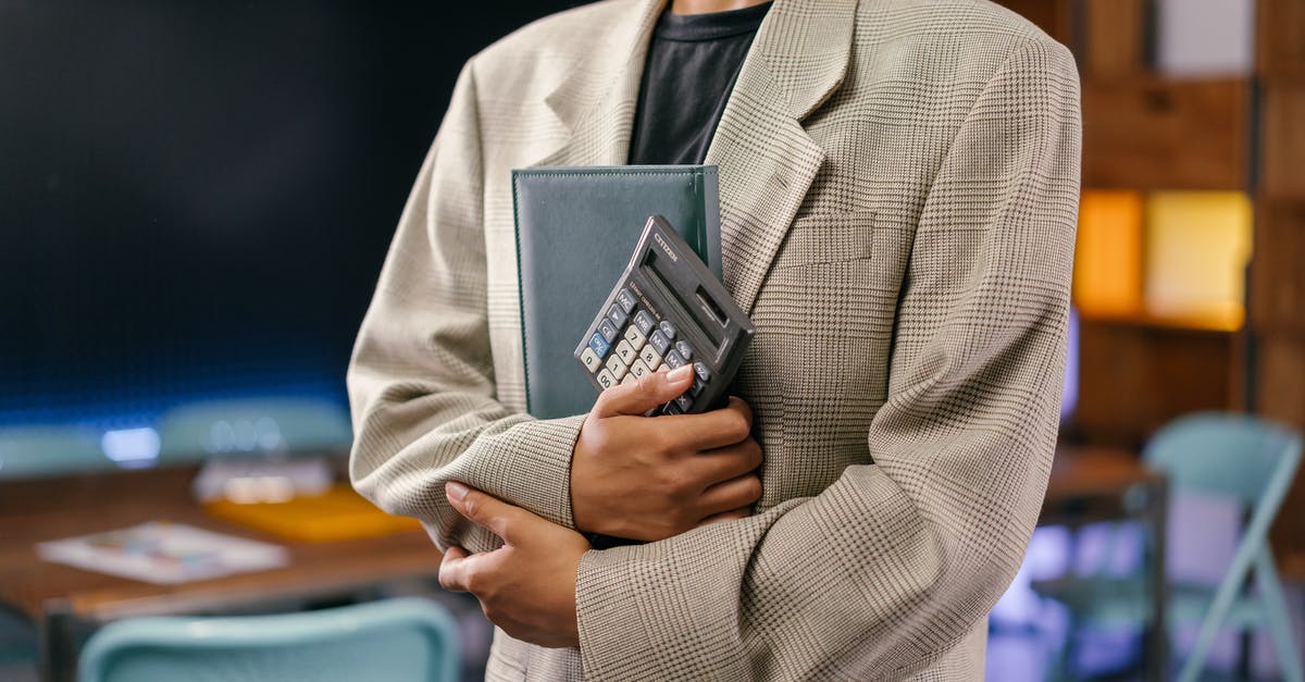 Carrying Bitcoin Internationally - Man in Gray Suit Jacket Holding Black Smartphone