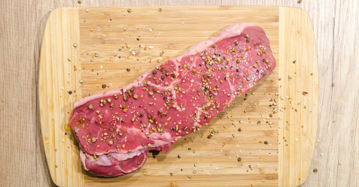 Carrying frozen raw meat in checked in baggage - Flat Lay Photography of Slice of Meat on Top of Chopping Board Sprinkled With Ground Peppercorns