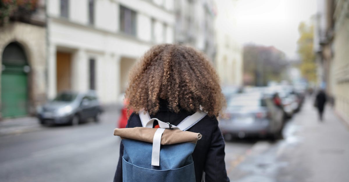 Carrying hard drives in checked in luggage - Woman in Black Coat Carrying Backpack 