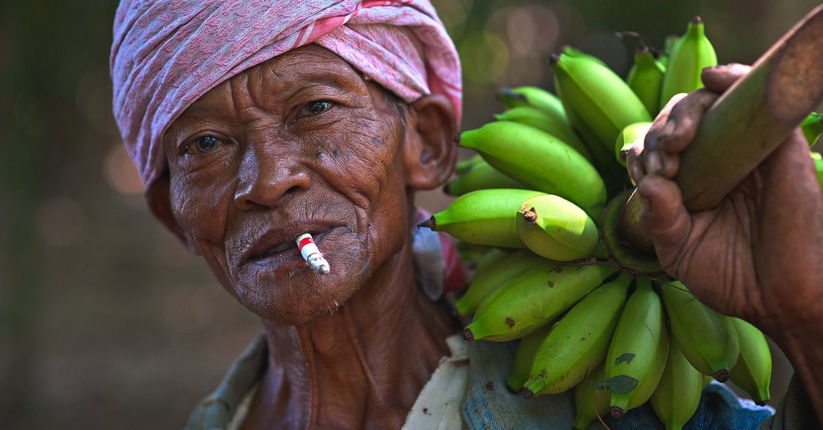 Carrying semi-solid food in flights? - Man Wearing Blue Top Holding Bunch of Unripe Bananas