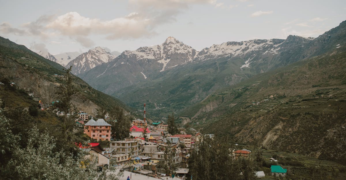 Carrying tea tree oil while traveling from London to India - Old town surrounded by mountains against cloudy sundown sky