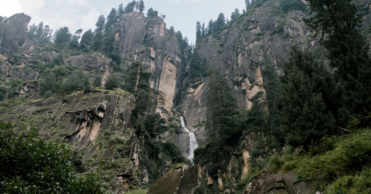 Carrying tea tree oil while traveling from London to India - Picturesque rocky ravine with waterfall and green vegetation