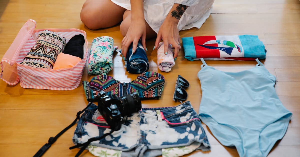 Carry-on bag packing advice [closed] - A Person Sitting on a Wooden Floor while Preparing Travel Essentials