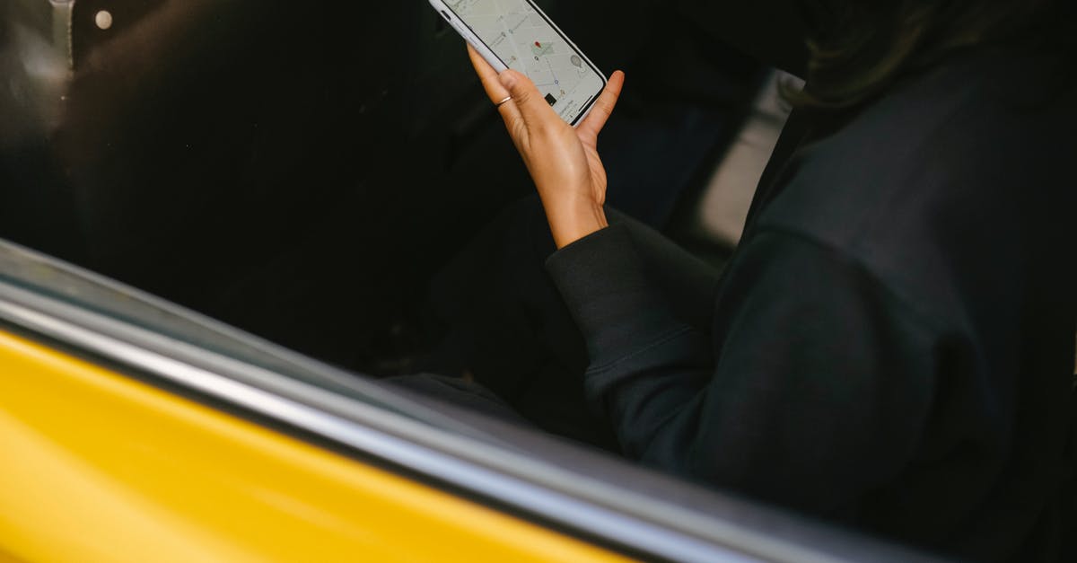 Categories passenger locator form essential travel via Belgium - Crop passenger with navigator app on smartphone in taxi vehicle