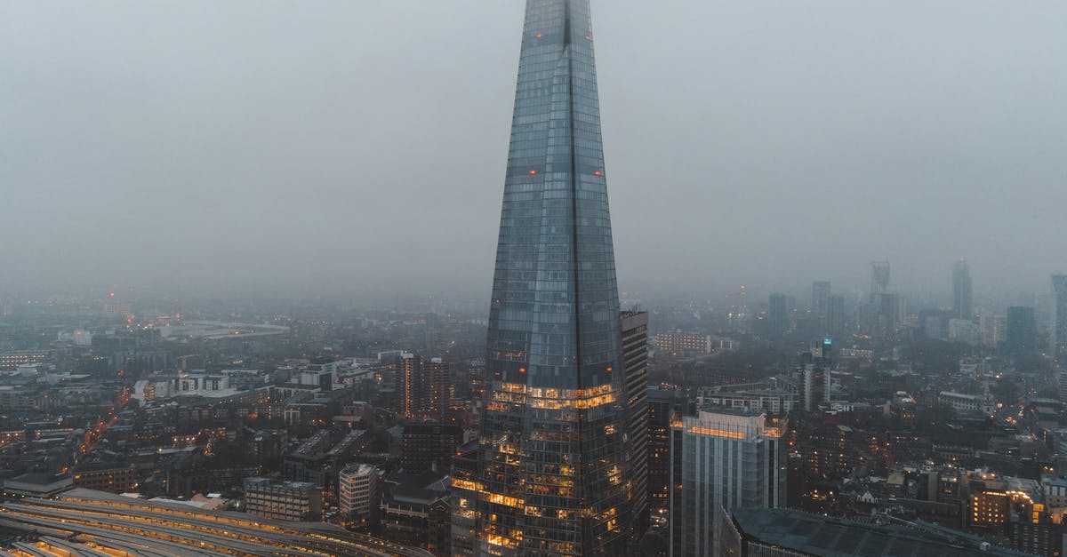 Central districts in London? - Aerial view of London city located in England with modern buildings and Shard skyscraper near railroads under gray cloudy sky in hazy day in daytime