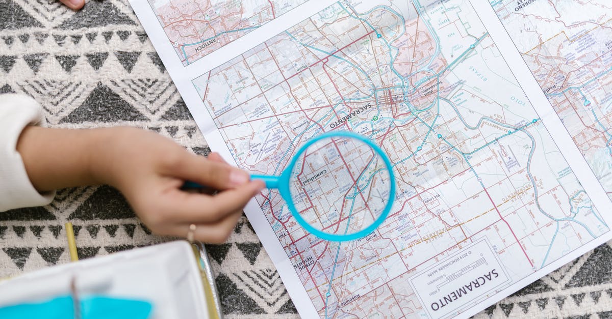 Change Osmand map to 2D-view [closed] - Person Holding Blue Magnifying Glass Over a Map