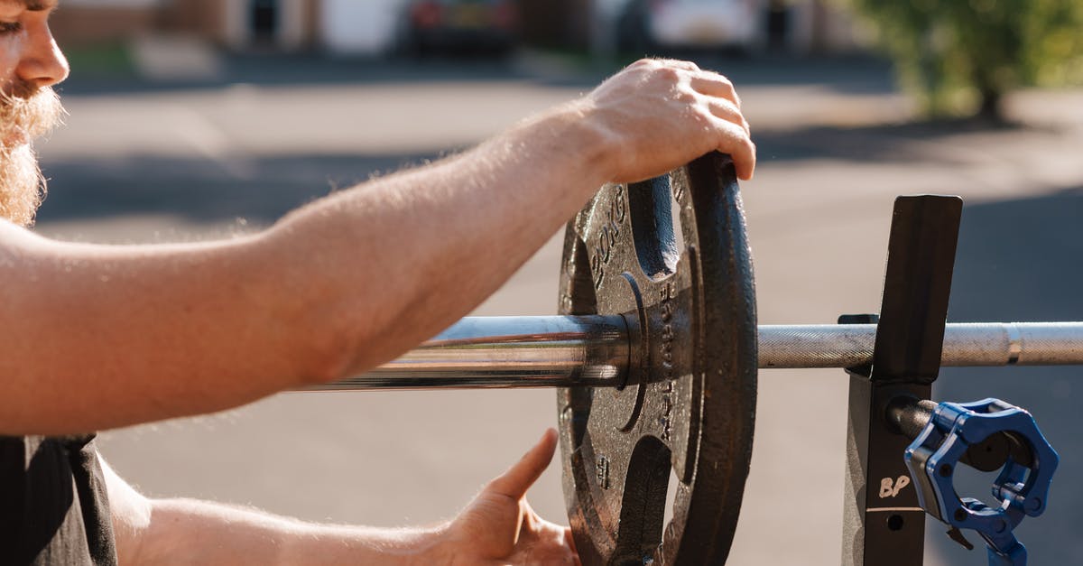 Change trains in Brest (Belarus) under 15 minutes? - Man putting weight on metal barbell