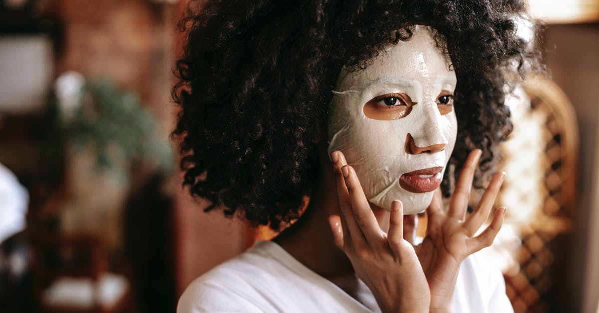 Changing a flight with layovers - does fee apply multiple times? [duplicate] - Calm young African American lady with curly hair applying moisturizing sheet mask while relaxing alone at home