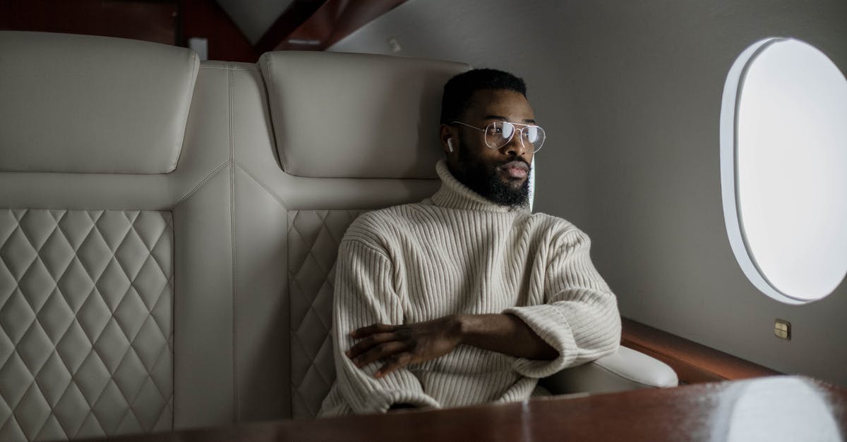 Changing a passenger on a Lufthansa flight - Man in White Sweater Sitting on White Leather Couch