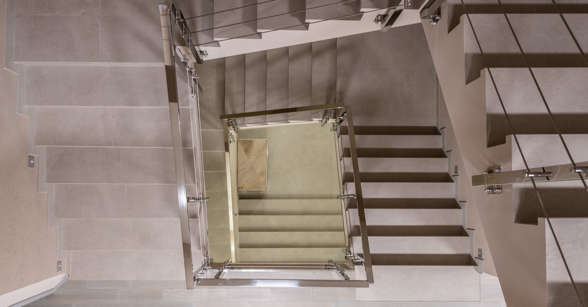 Changing dates for part of a flight - Top view flights of stairs with metal handrails and fencing located in light modern spacious multistory building with laminate floor