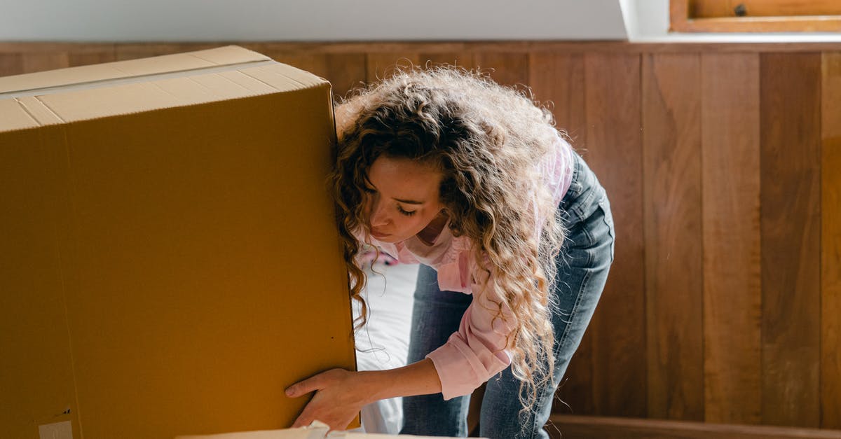 Changing domestic itinerary on a Spain Schengen visa - Young woman unpacking boxes in light apartment