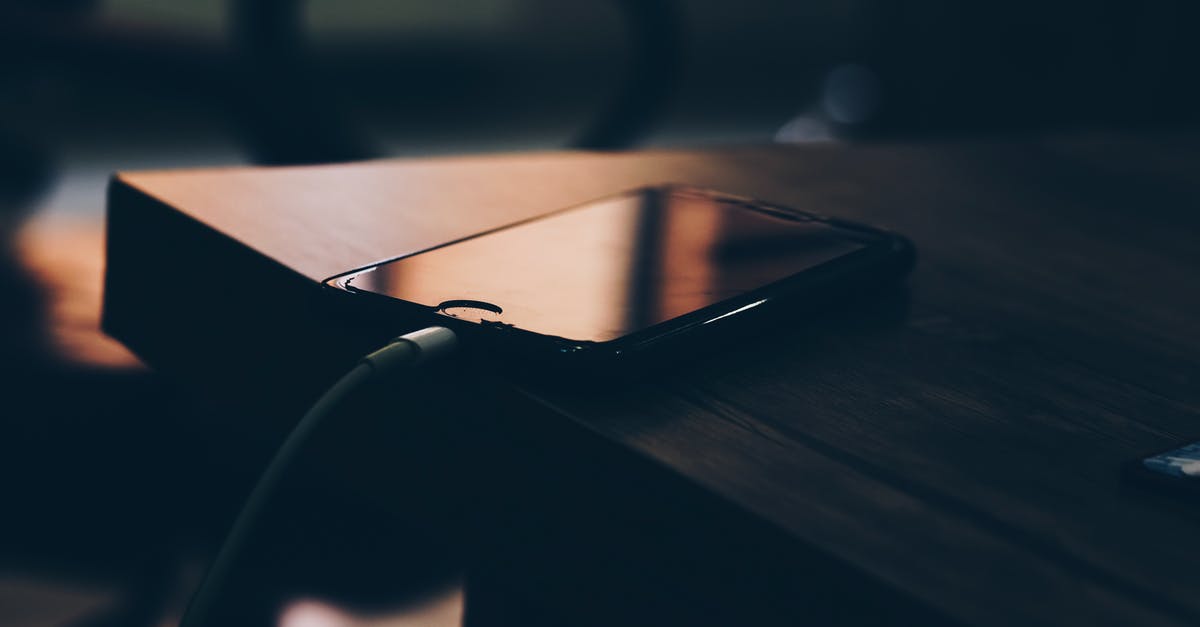 Charge iPhone in Europe - Shallow Focus Photography of Black Iphone 7 on Brown Wooden Table