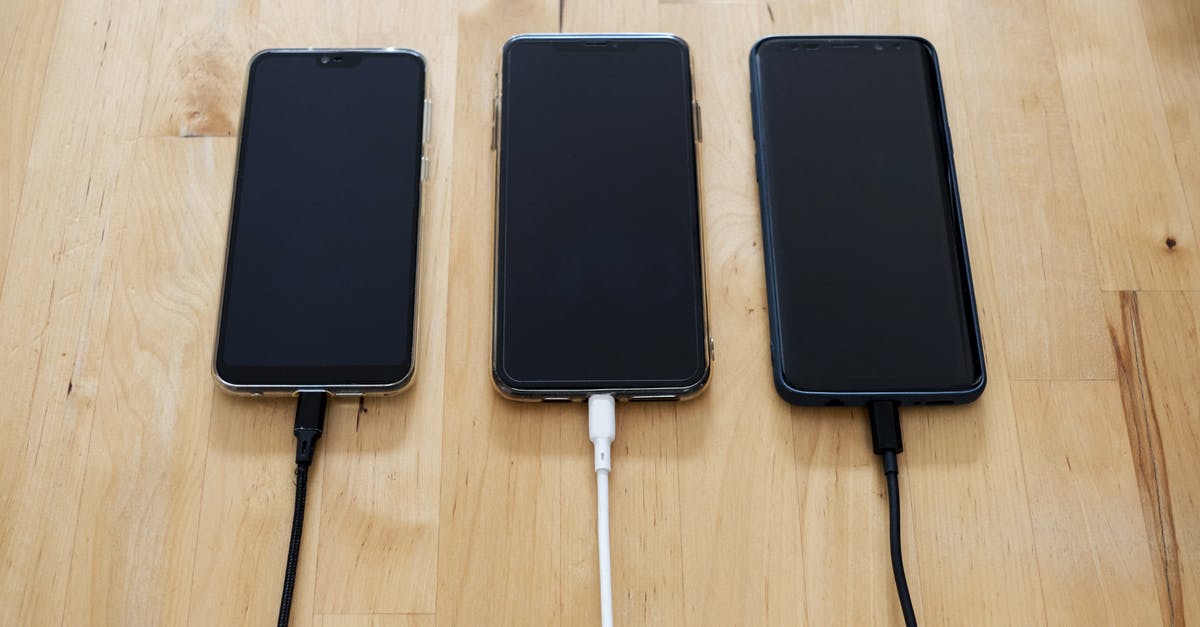 Charging mobile phones in Mongolia - Black Android Smartphones on Brown Wooden Surface