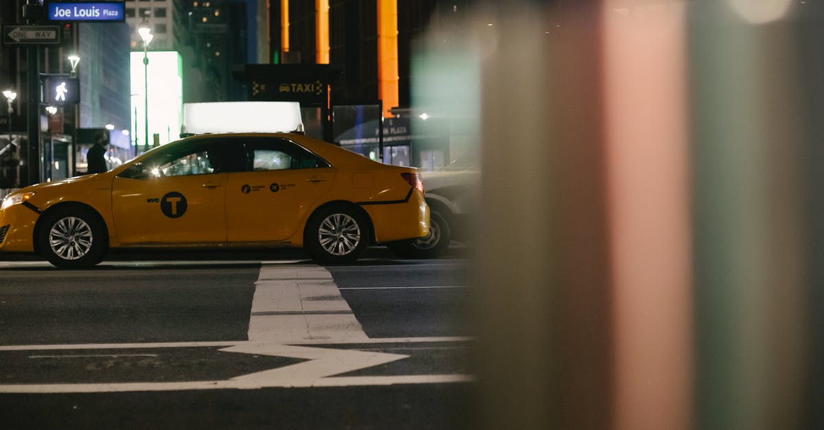 Cheap and convenient way to travel with kids around US - Contemporary taxi car driving on city street at night