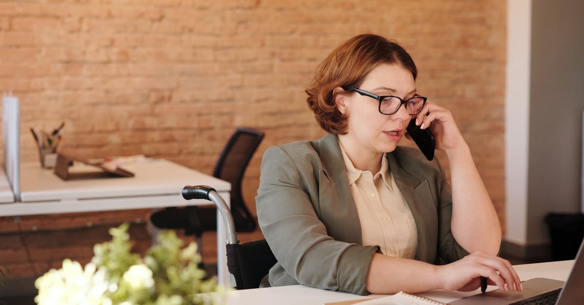 Cheap phone calls from Canada to Poland - Photo of Woman Talking Through Smartphone While Using Laptop