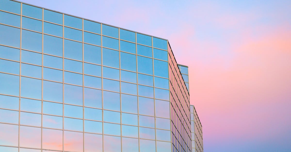 Cheap short-term accommodation in downtown Vancouver - Exterior of contemporary building with glass mirrored walls located in city against colorful sky at sunrise time