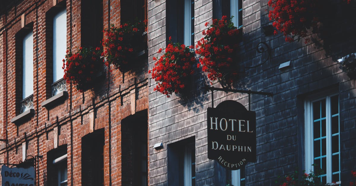 Cheapest hotel in Europe - Facade of modern masonry building decorated with red flowers